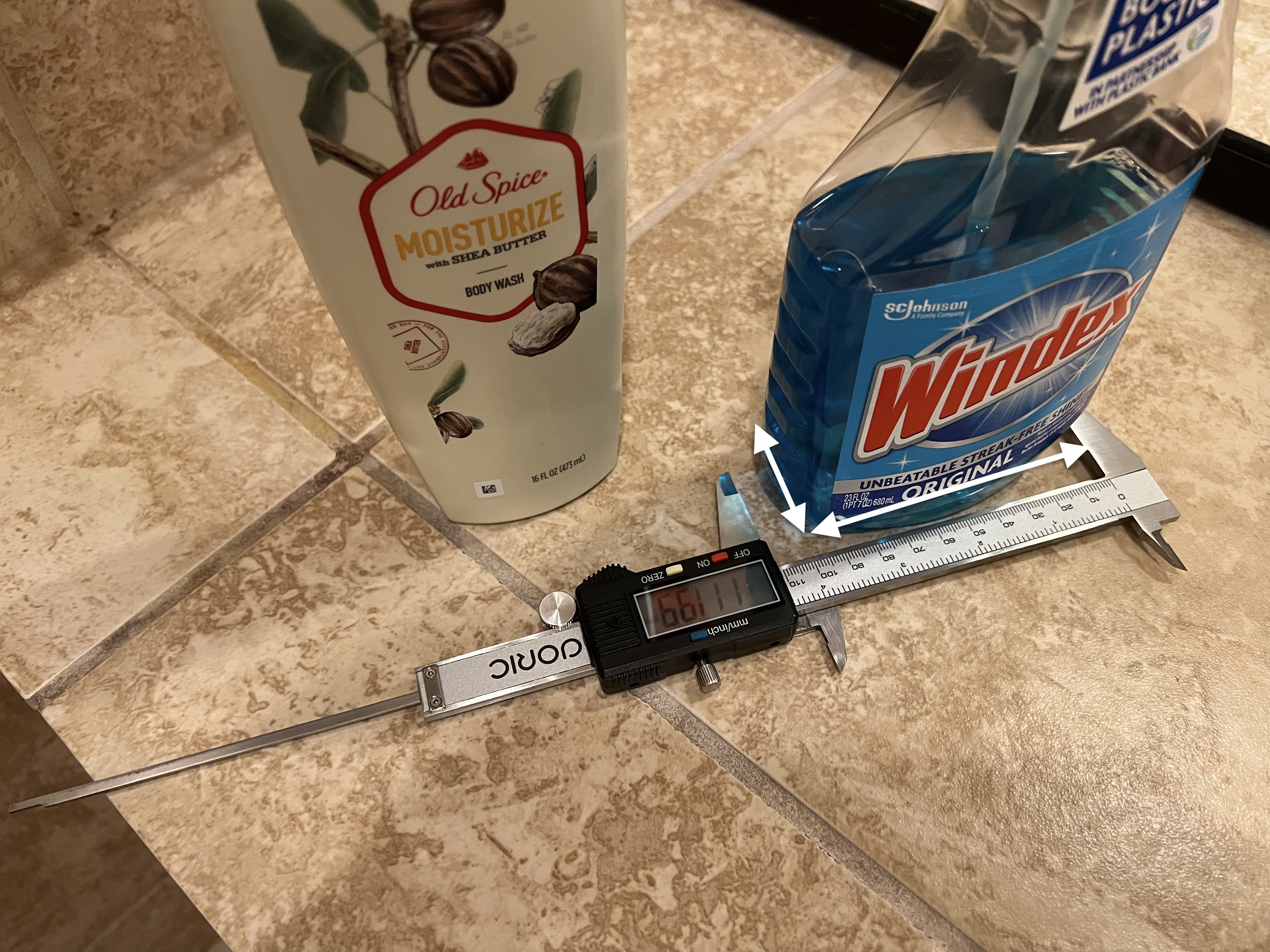Photograph of measurements of shower accessories with rectangular bases including Windex bottle and body wash